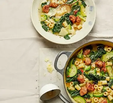 An image of sausage and kale minestrone soup in a pot and on a plate.