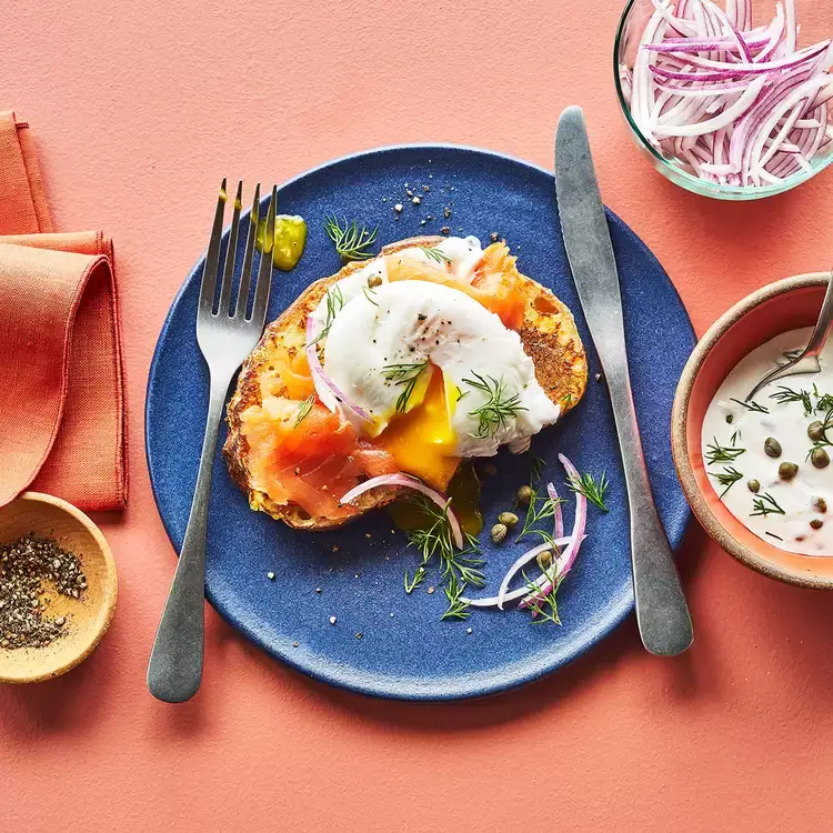 An image of a plate with french toast, eggs and salmon on top